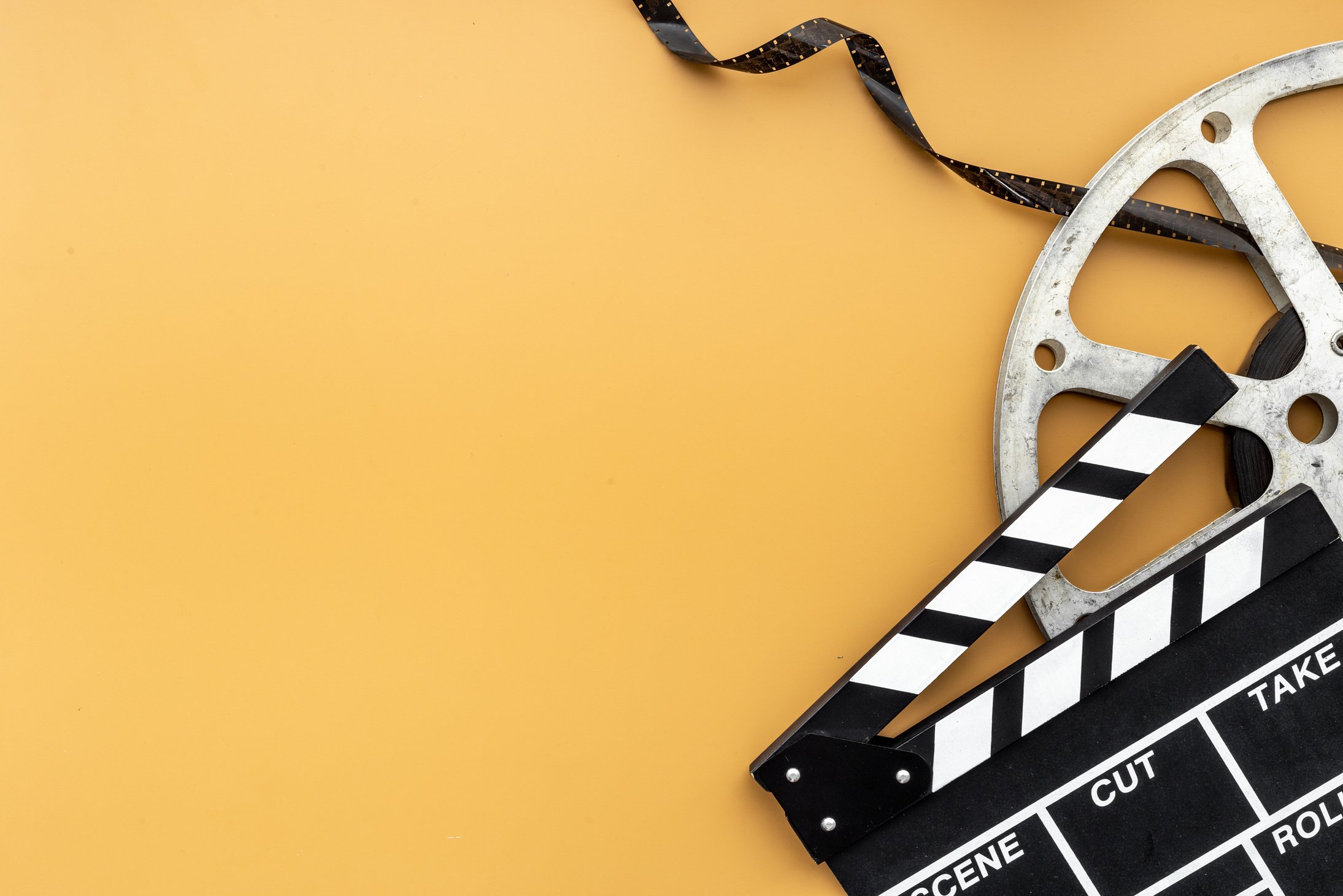 Cinema background with movie clapperboard and film reel